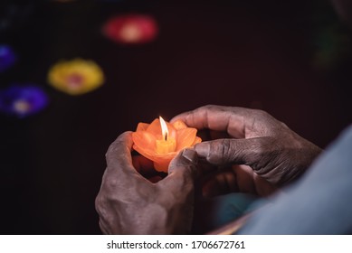 Older hands holding candle light and praying with god for good life and peace of people.