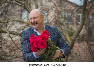 Older happy Senior man with a bouquet of flowers waiting on a date. Mature people lifestyle