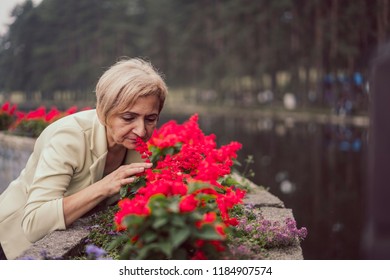 Older Happy Woman Smelling Flower 