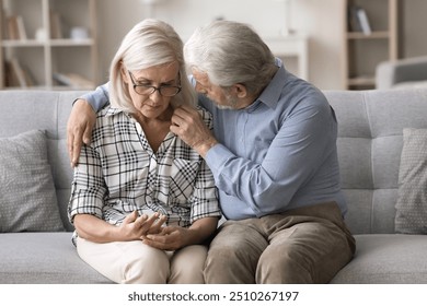 Older husband comforting frustrated beloved woman. Sad mature wife grappling with health issues or chronic pain, loving man offers comfort and encouragement, reassuring her, provide sincere support - Powered by Shutterstock