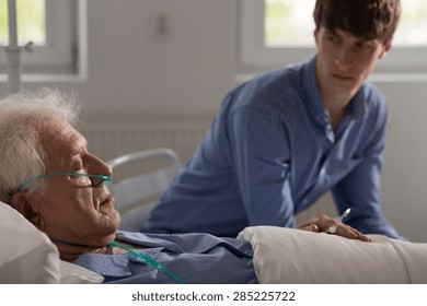 Older Ill Man With Nasal Cannula Sleeping In Hospital Bed