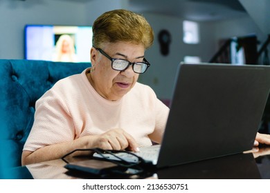 Older Latina Woman Using A Laptop Computer. Close Up, Wearing Glasses With Protection, Going Blind She Can Hardly See.