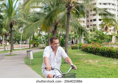 Older Latino man riding a bicycle in the park