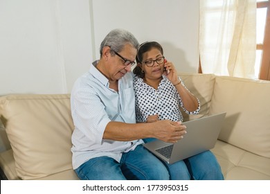Older Latino web-surfing couple with laptop and cell phone. Two smiling older Latinas sharing and looking at the laptop - older couple with modern technology
