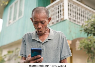 An Older Man Amazed At Seeing A Sexy Picture Or An Interesting Social Media Post On His Cellphone. Making An Inadvertently Funny Face While Watching A Video.