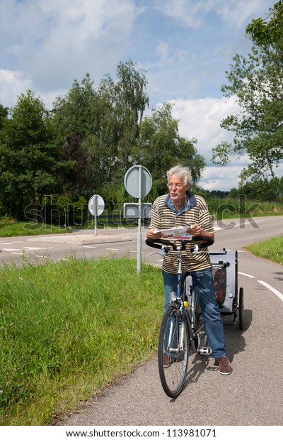 older man with bike and dog car is checking the\
biking route