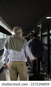 Older Man Boarding The Plane Through The Gate