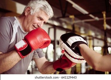 Older man boxing in gym. Senior man with personal trainer. - Powered by Shutterstock