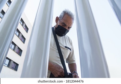 älterer Mann, der sich hinter Gitterstäben mit schwarzer Maske auf das Pflegeheim beschränkt