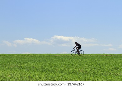 Older man cycling trough the fields