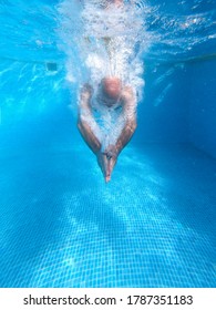 Older Man Dives Into The Blue Water Pool During The Summer Holidays.