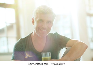 Older man drinking glass of juice - Powered by Shutterstock