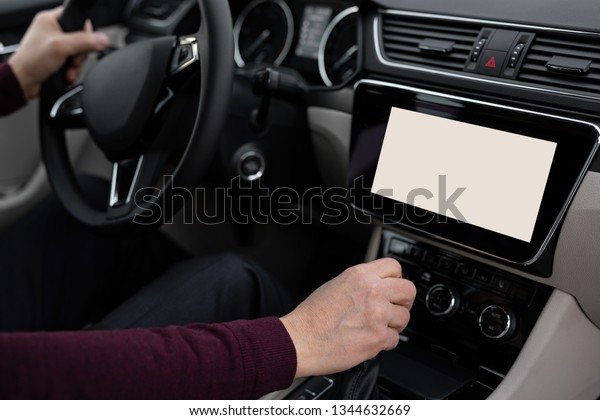 Older man is driving the car and using the\
navigation system
