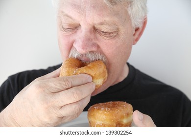 Older Man Enjoys A Bakery Yeast Doughnut