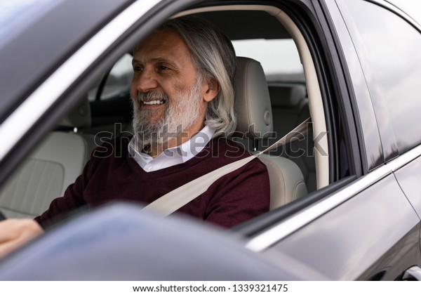 Older man enjoys driving his\
car