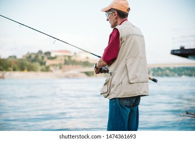 An Older Man Fishing On A River