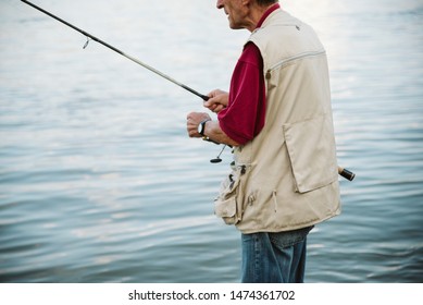 An Older Man Fishing On A River