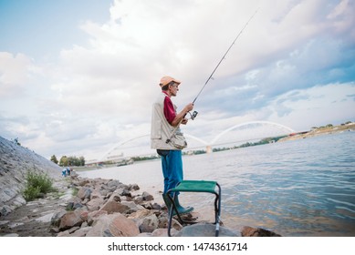 An Older Man Fishing On A River