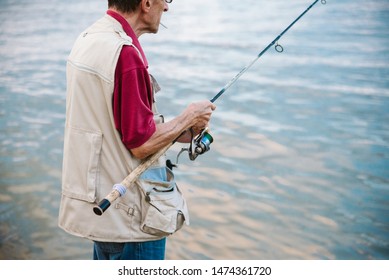 An Older Man Fishing On A River