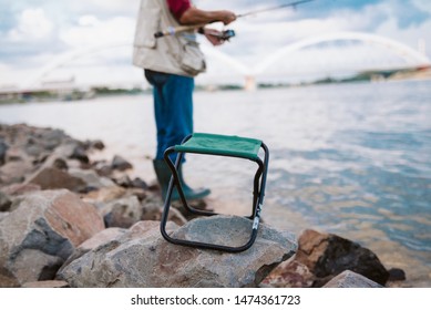 An Older Man Fishing On A River