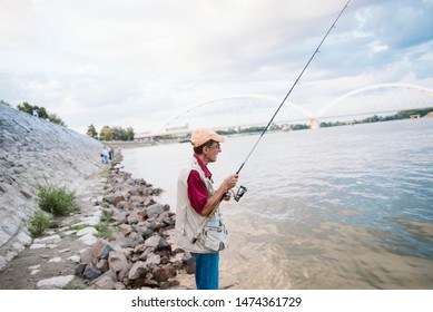 An Older Man Fishing On A River