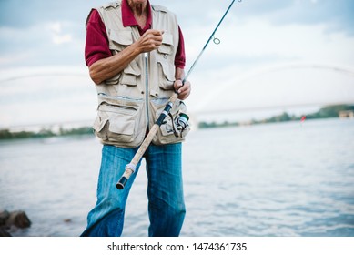 An Older Man Fishing On A River