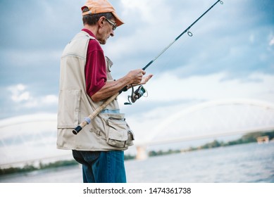 An Older Man Fishing On A River