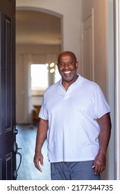 Older Man At The Front Door Of His House Welcoming People In