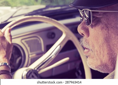 Older Man With Glasses Driving A Car