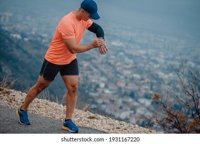 Older Man In Good Shape Checking His Wrist Watch During A Run
