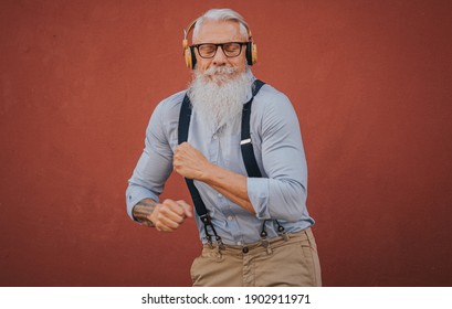 An Older Man In Hipster Clothes And Glasses And Long White Beard Listens To Music And Dance Happily In The Street Focus On Head