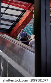 Older Man With Large Heavy Backpack On His Shoulder Climbing Large Stairs In Commune 13