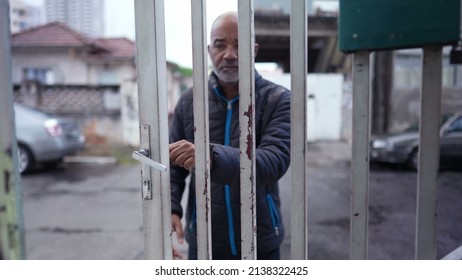 An Older Man Leaving House In The Drizzle Opening Entrance Door And Going Out To Street