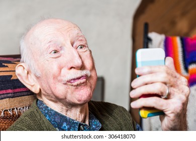 Older Man Looking At Camera While Taking Silly Face Selfie