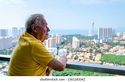 Older man looking over city from balcony - Powered by Shutterstock