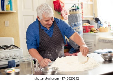 Older Man Making Bread At Home - Hispanic Man Preparing Dough For Bread- Smiling Grandfather Baking