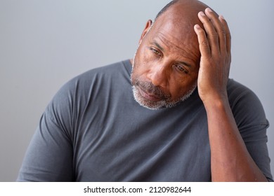 Older man not feeling well and rubbing his head