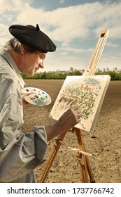 Older Man Painting Artwork On Canvas In Sunny Day Field