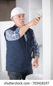 Older Man Painting The Wall