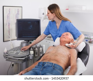 Older Man Patient Undergoing Examination Thyroid Lying By Woman Doctor With Ultrasonography Device