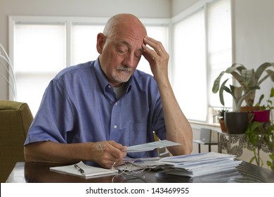 Older man paying bills.
