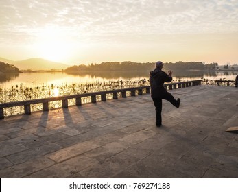 Older Man Practising Tai Chi During Sunrise In Xuanwu Lake Park, Nanjing, China