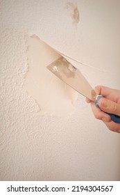 Older Man Removing Old Wallpapers Off The Walls In Empty Apartment