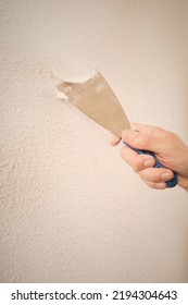 Older Man Removing Old Wallpapers Off The Walls In Empty Apartment