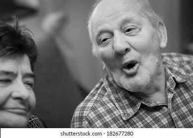 An Older Man Singing At Home