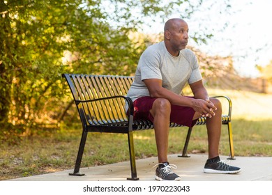 Older Man Sitting On A Park Bench Mediating.