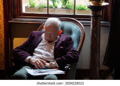 Older Man Sleeping On A Sofa Inside A Victorian Style Room. May, 2 2012. London. UK.