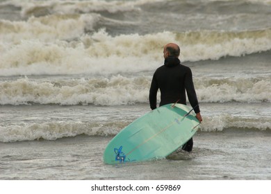 Older Man With Surf Board In Ocean