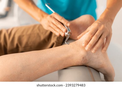 An older man is treated in a physiotherapy clinic with a hook and diacutaneous fibrolysis technique in the foot and ankle area - Powered by Shutterstock