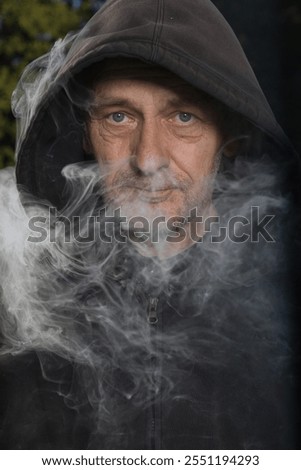 Older man uses two types of smoke machine generators on outdoor location